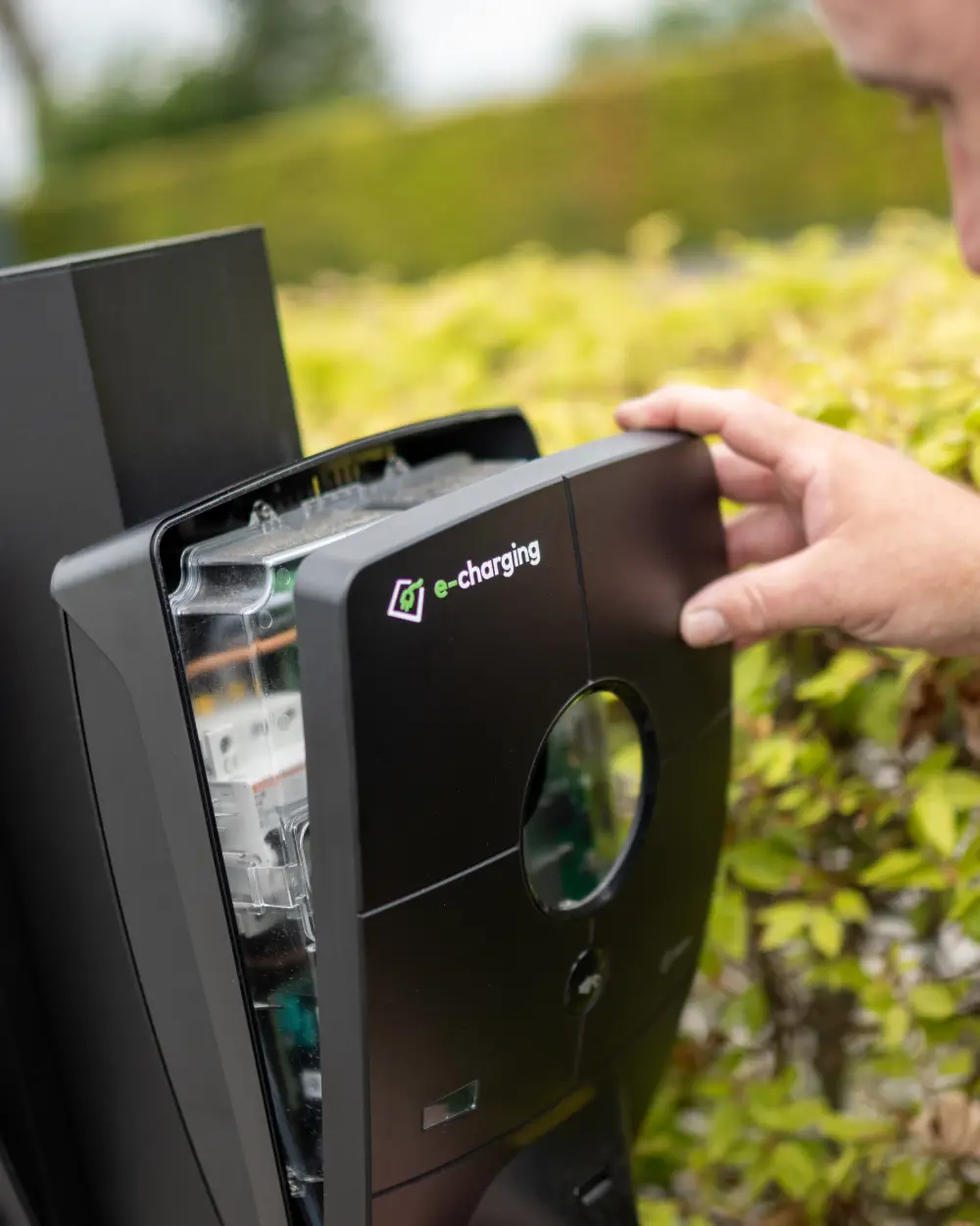 De frontkap gaat van een laadpaal af, met de installatieautomaten zichtbaar